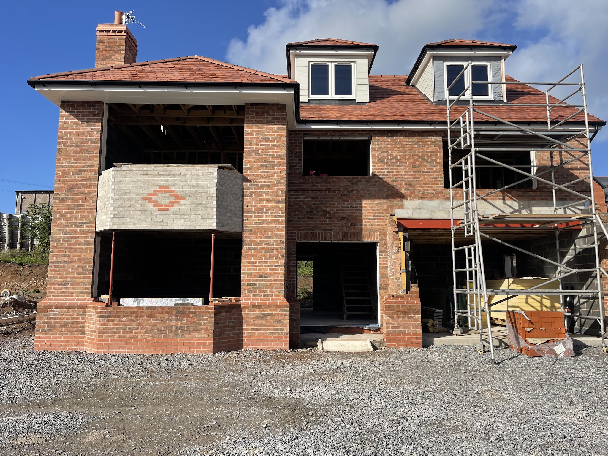 A brick house being renovated and extended, with scaffolding up