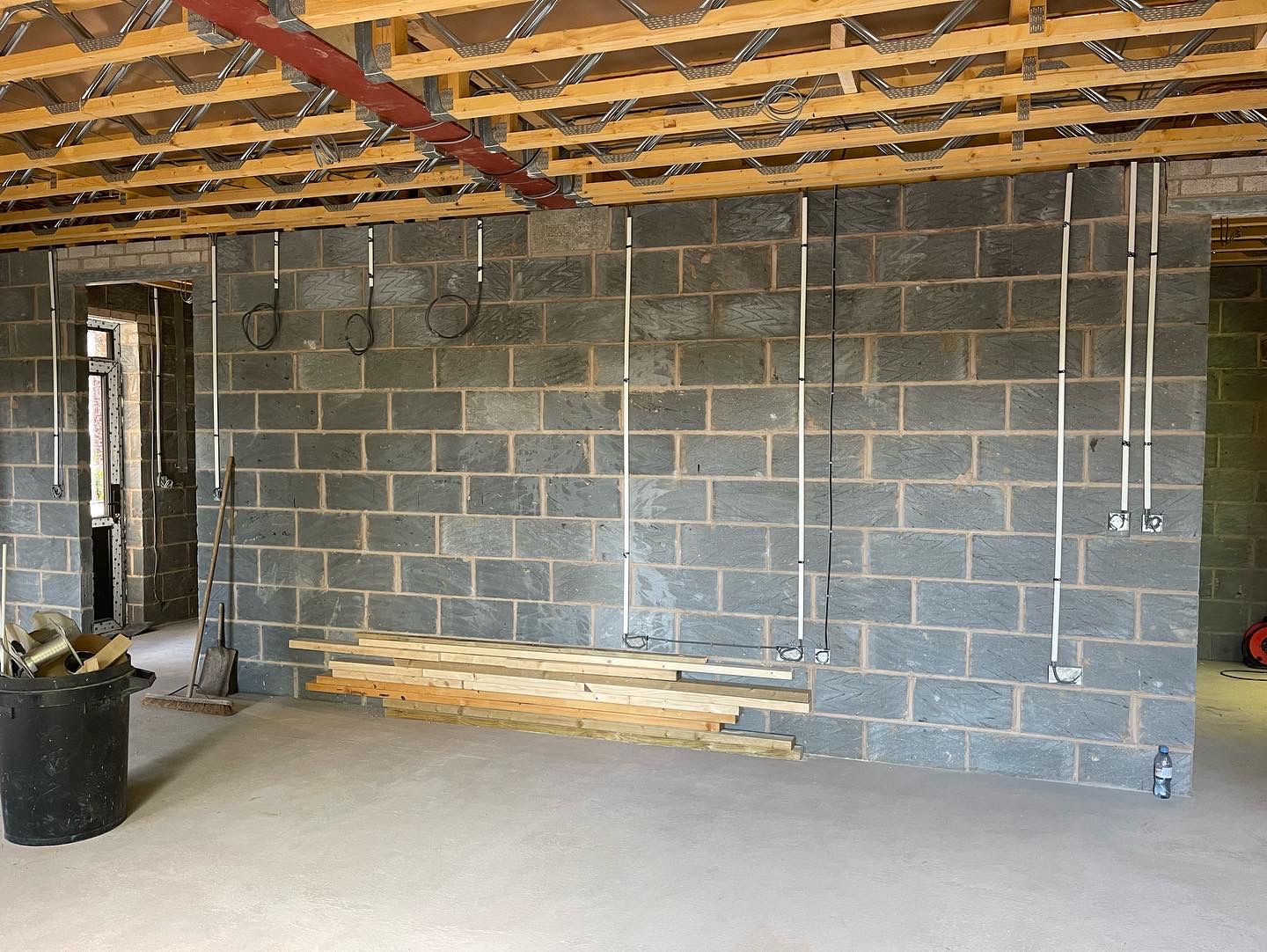 A blockwork extension shell with first fix conduit drops on the wall
