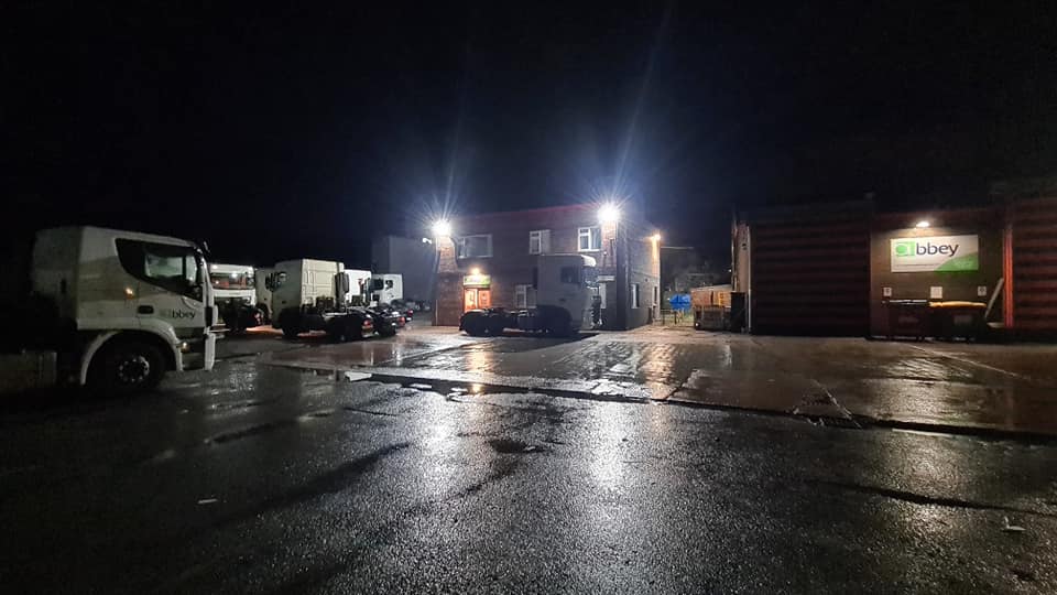 Industrial yard with lorries under new floodlighting at night
