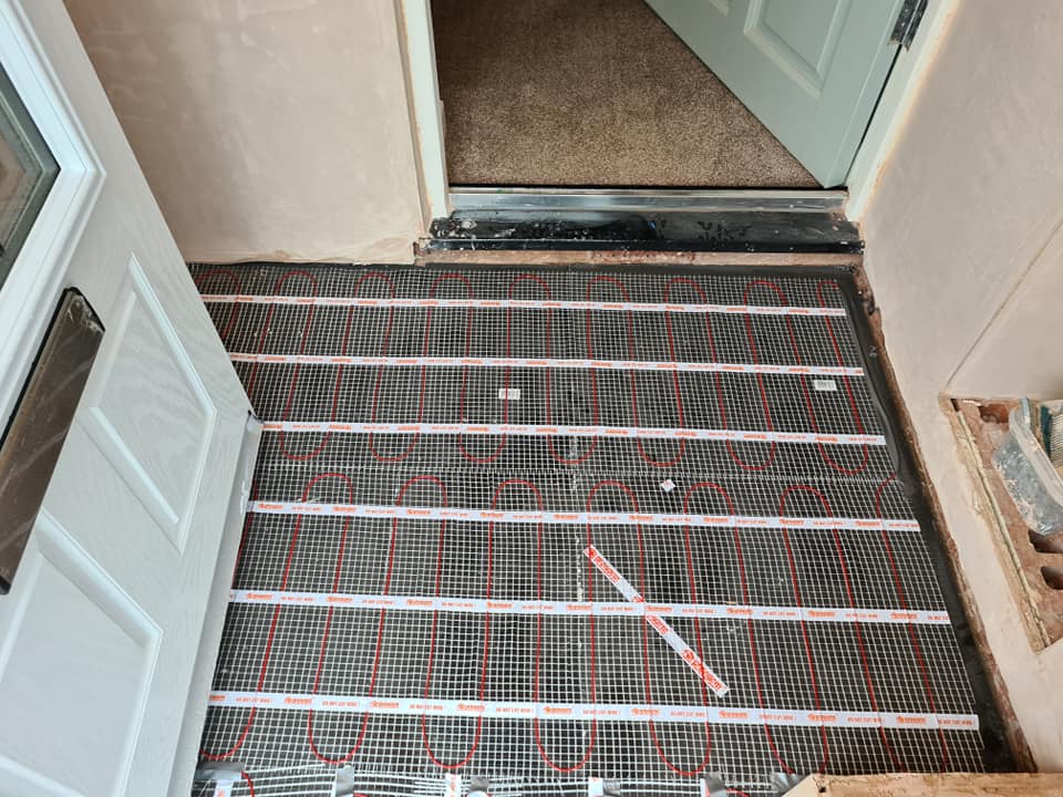 An electric underfloor heating mat laid in a doorway area