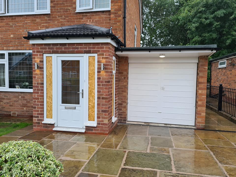 The front of a house with a new porch, garage and porch light