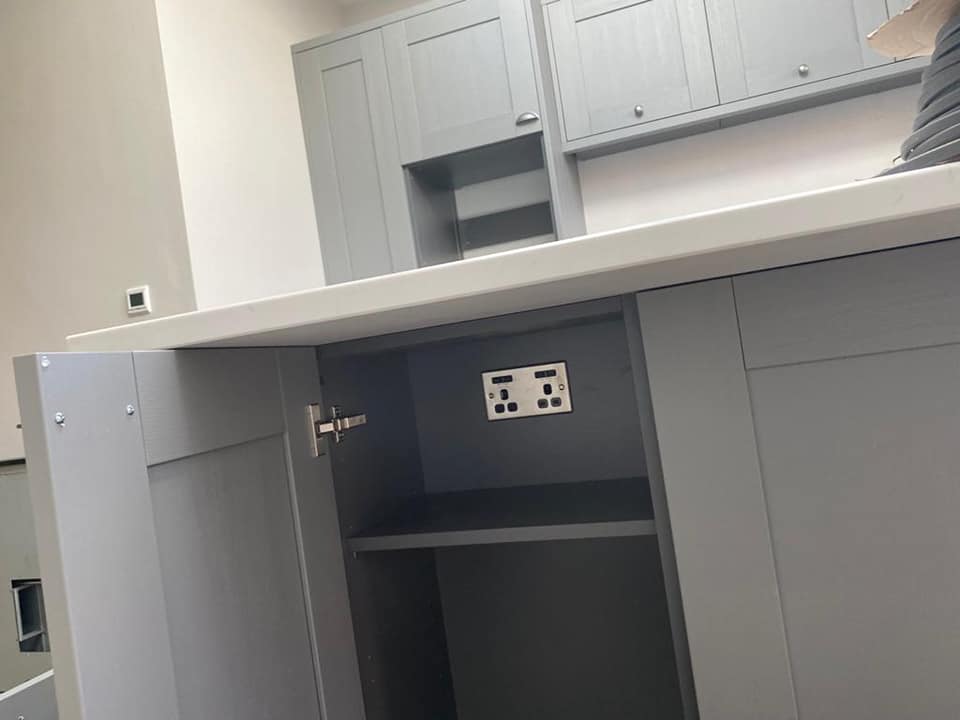 A double socket set into a kitchen cabinet