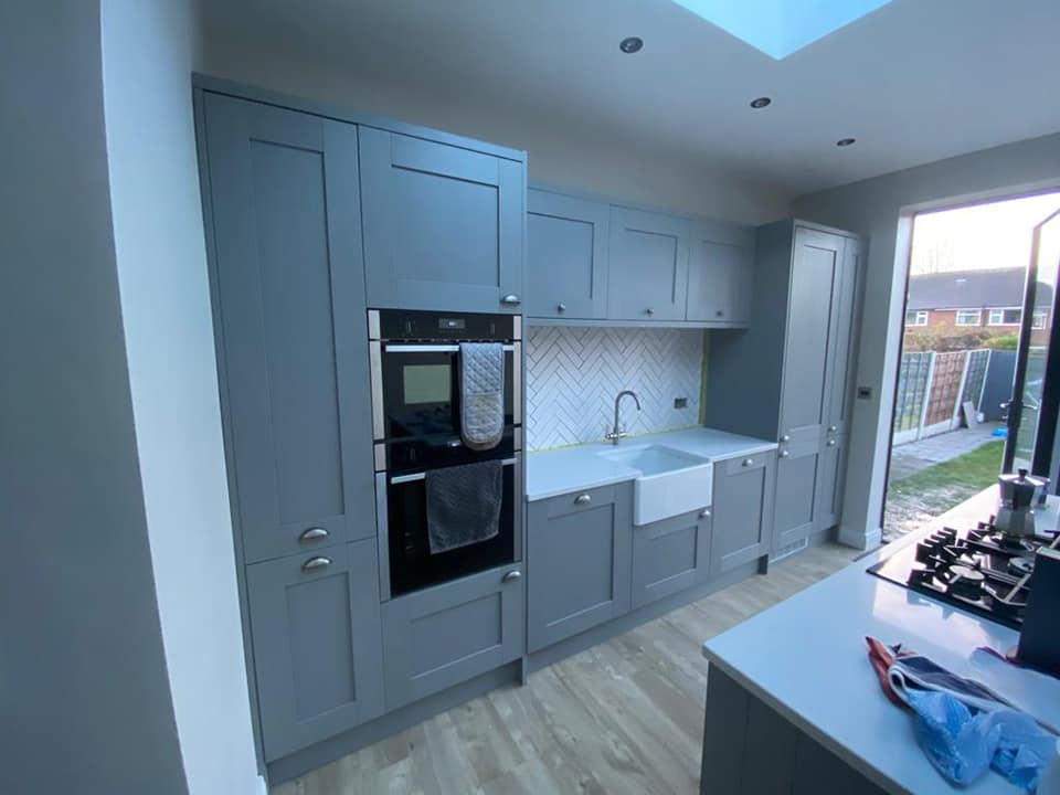 A finished grey shaker kitchen with integrated ovens