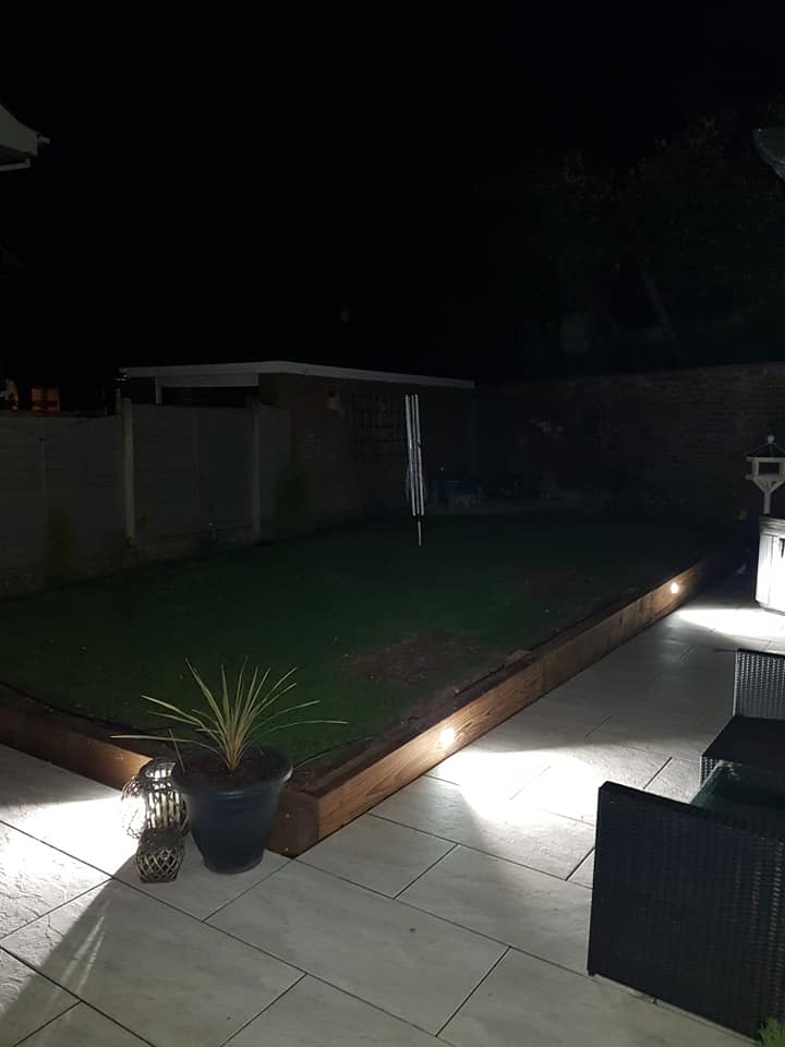 A patio at night lit by low-level lights